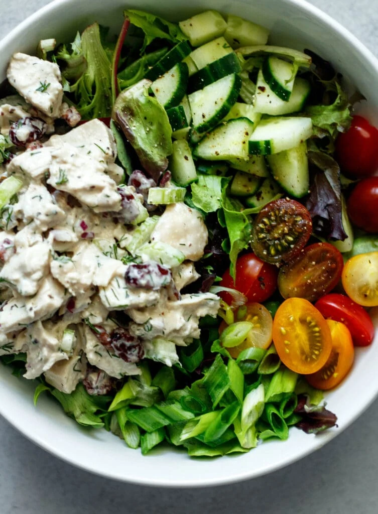 chicken salad on mixed greens with cucumbers, tomatoes, and green onions