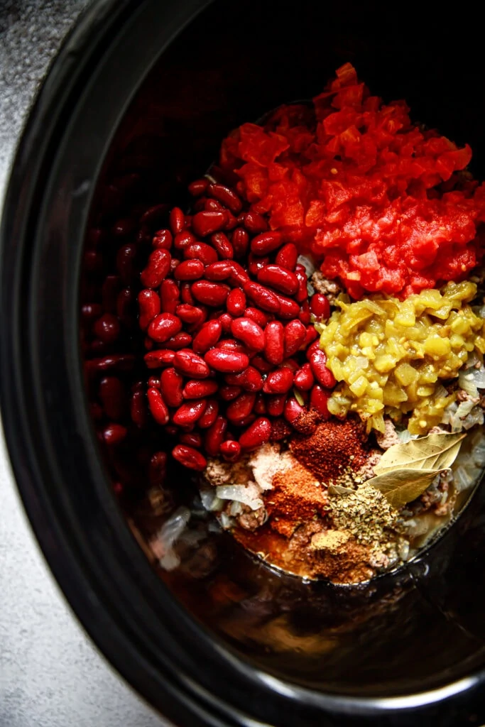 chili ingredients in a black slow cooker