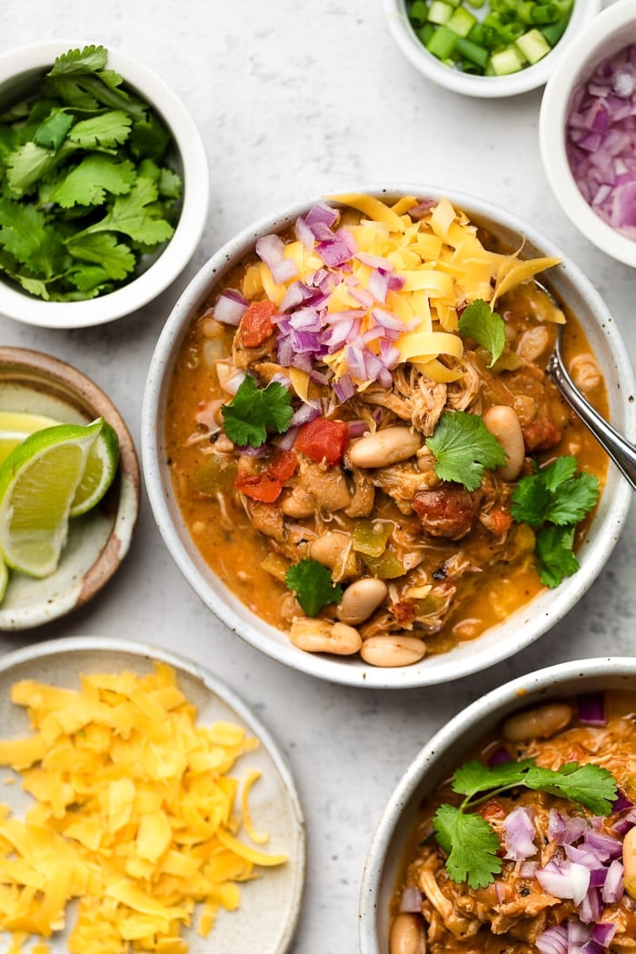 chicken chili in a white bowl with toppings
