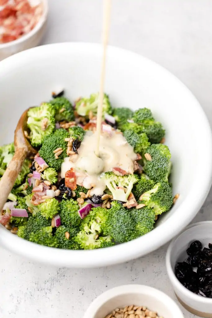 dressing being drizzled on broccoli