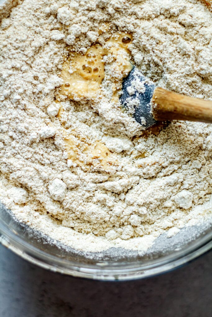 oat flour in the banana batter with spatula in clear glass bowl
