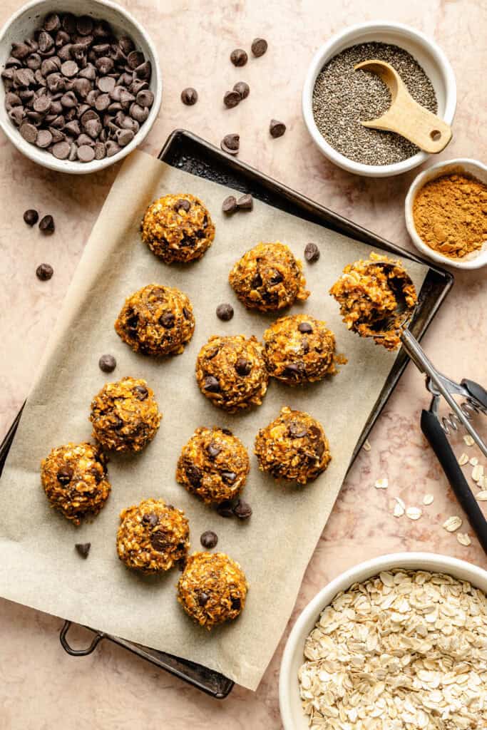 pumpkin spice energy bites being scooped on sheet pan