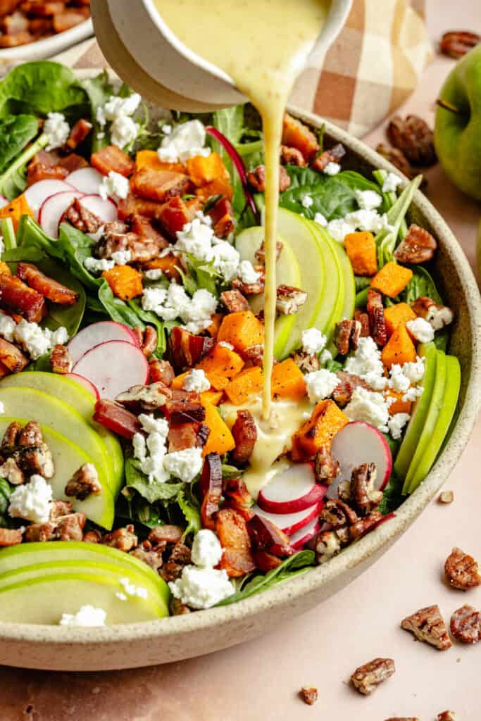 dressing being poured over salad