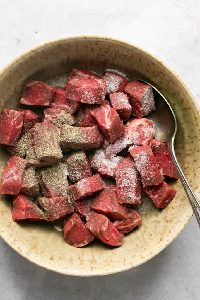 beef tips in bowl with salt and pepper