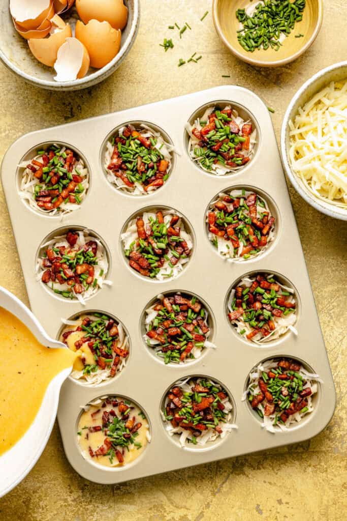 egg mixture being poured into muffin pan