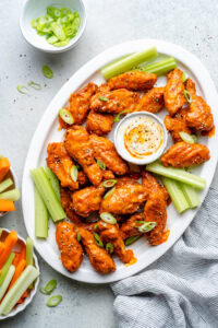 crispy baked buffalo chicken wings on platter with dip