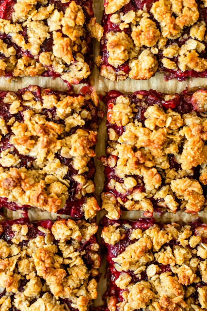 strawberry oatmeal bars cut into squares on parchment paper