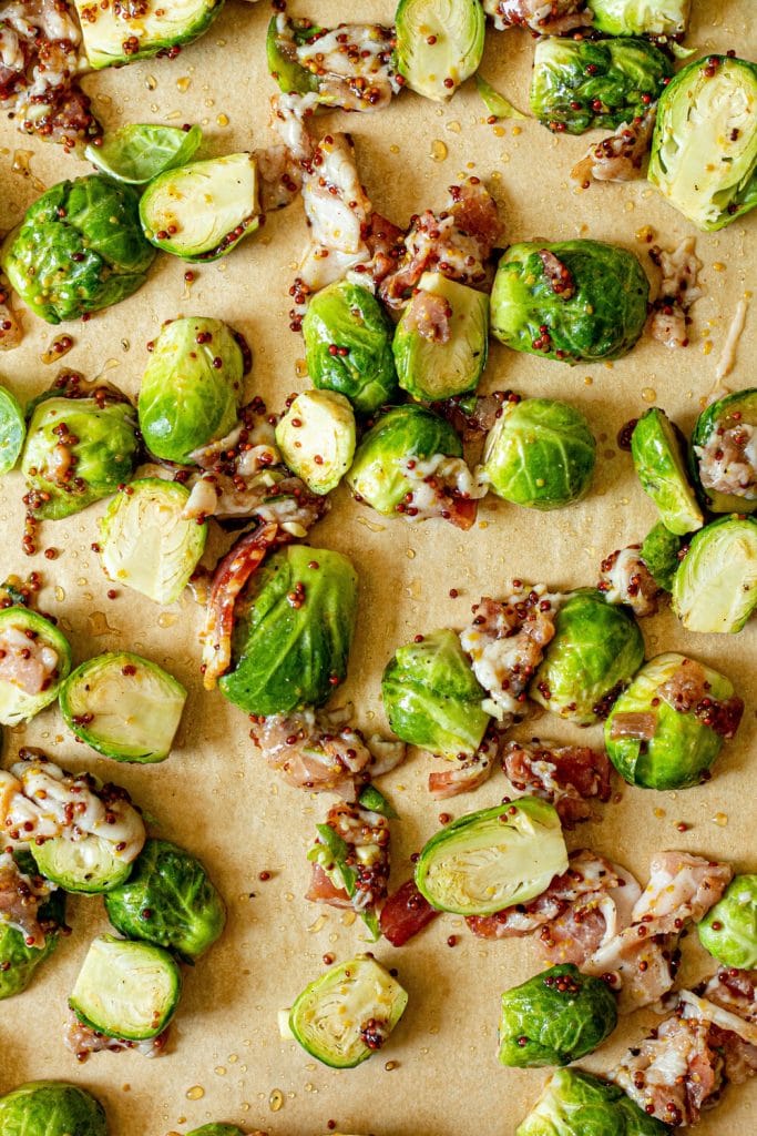 raw brussels and sliced bacon on baking sheet