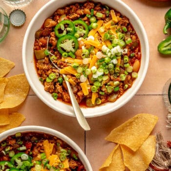 white bean turkey chili in bowl with spoon and toppings