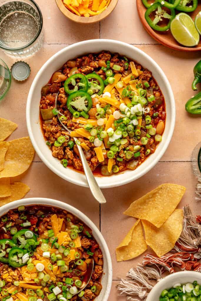 white bean turkey chili in bowl with spoon and toppings