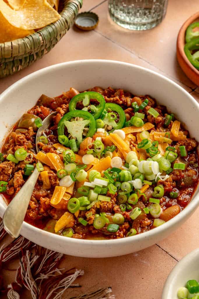 chili in bowl with spoon and toppings