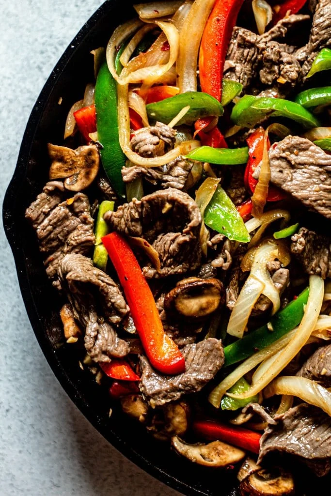 steak and peppers in a cast iron skillet