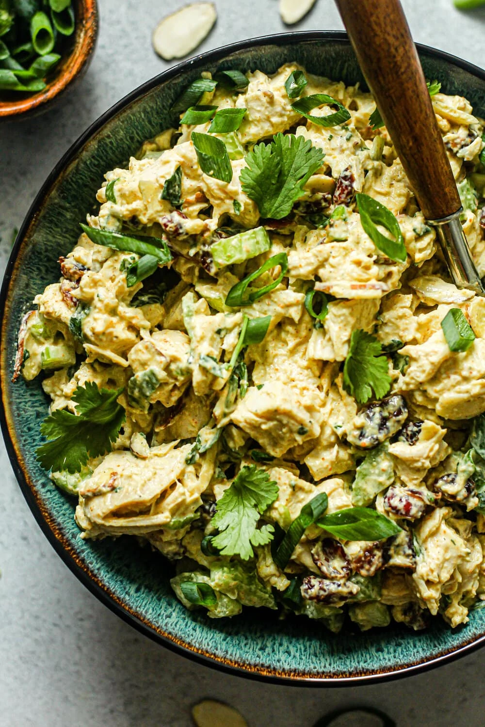 Curry Chicken Salad in a blue bowl with brown fork 