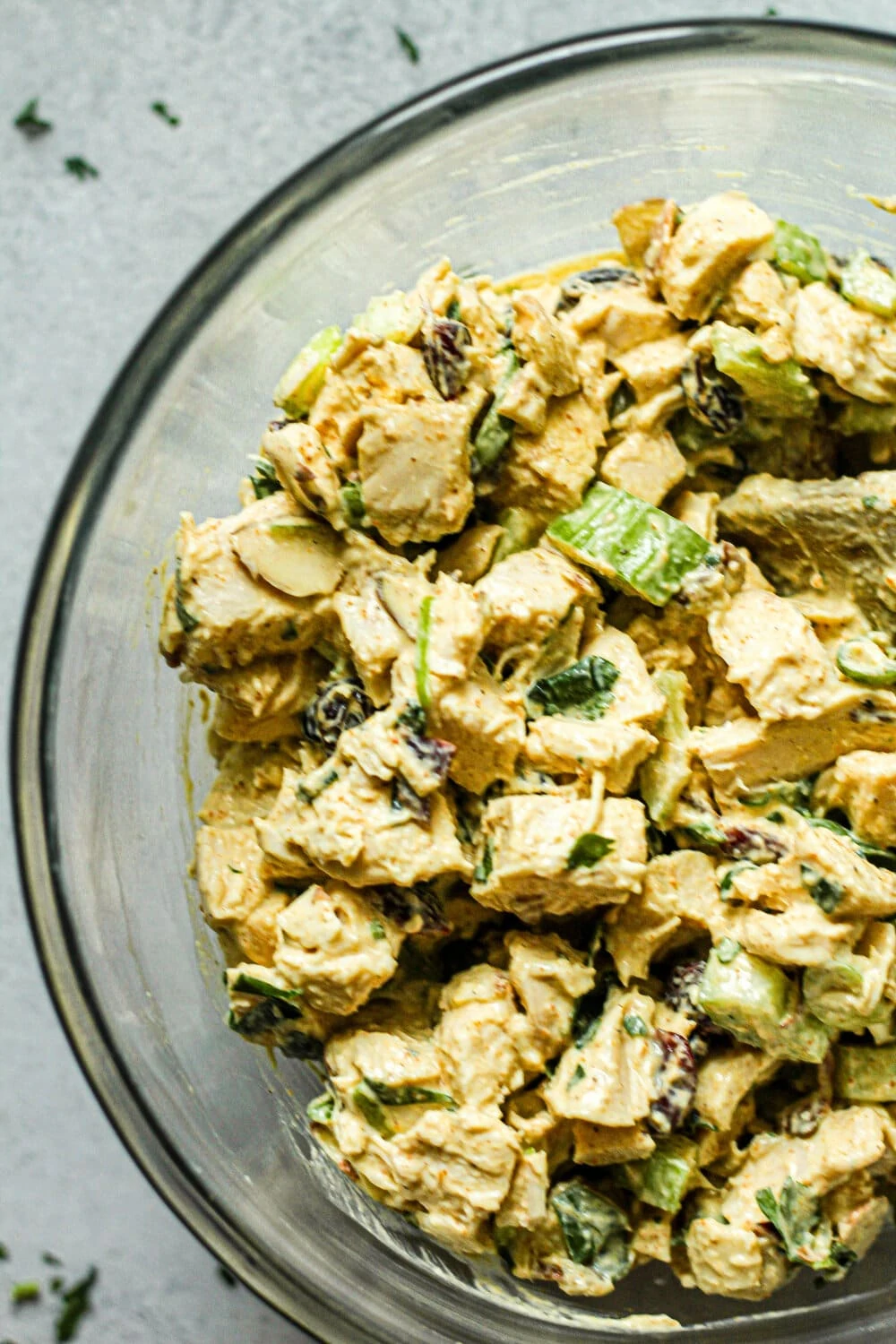 Curry Chicken Salad ingredients stirred together in glass mixing bowl