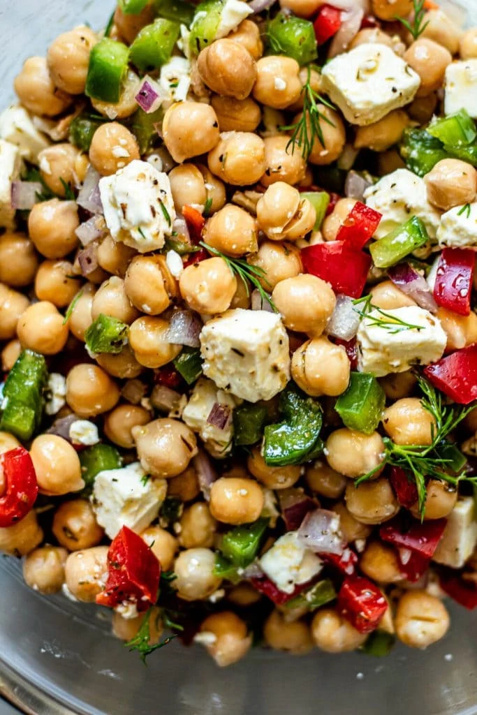 Greek chickpea salad in glass mixing bowl 