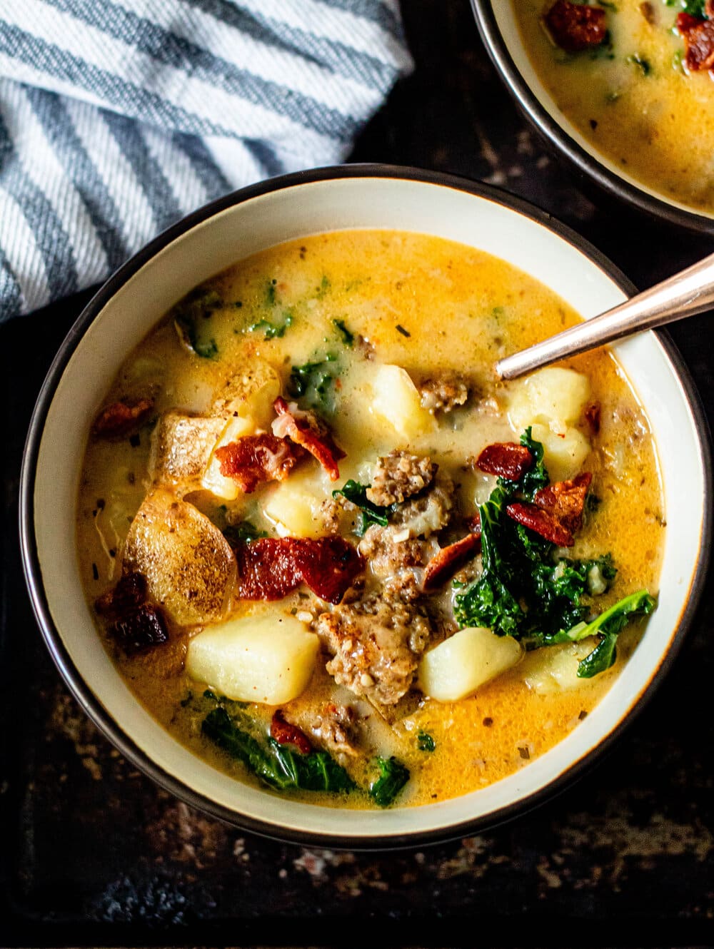 Whole30 Zuppa Toscana Soup on a dark sheet pan with gold spoon
