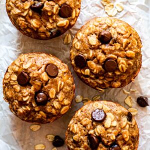 peanut butter banana baked oatmeal cups on white parchment paper