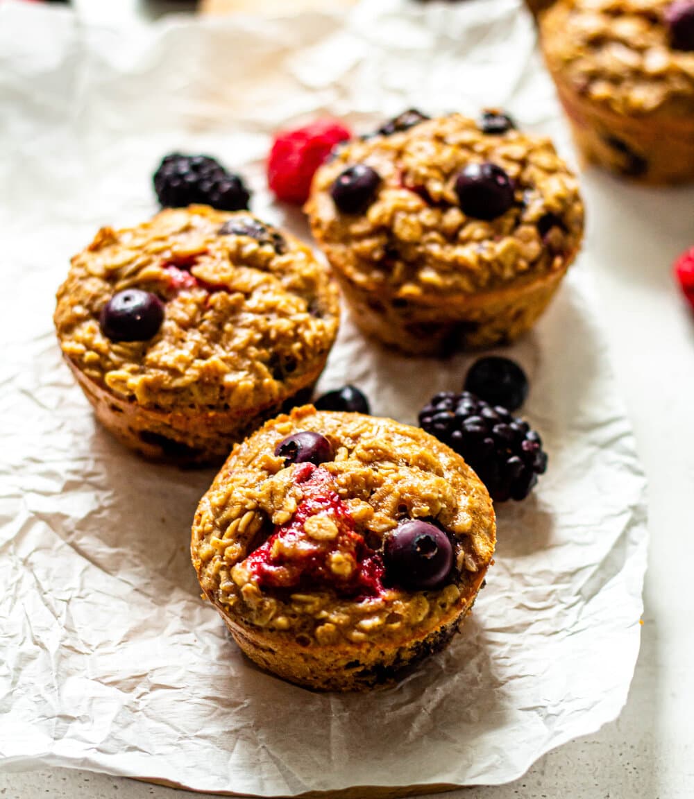 Triple Berry Baked Oatmeal Cups on white parchment paper