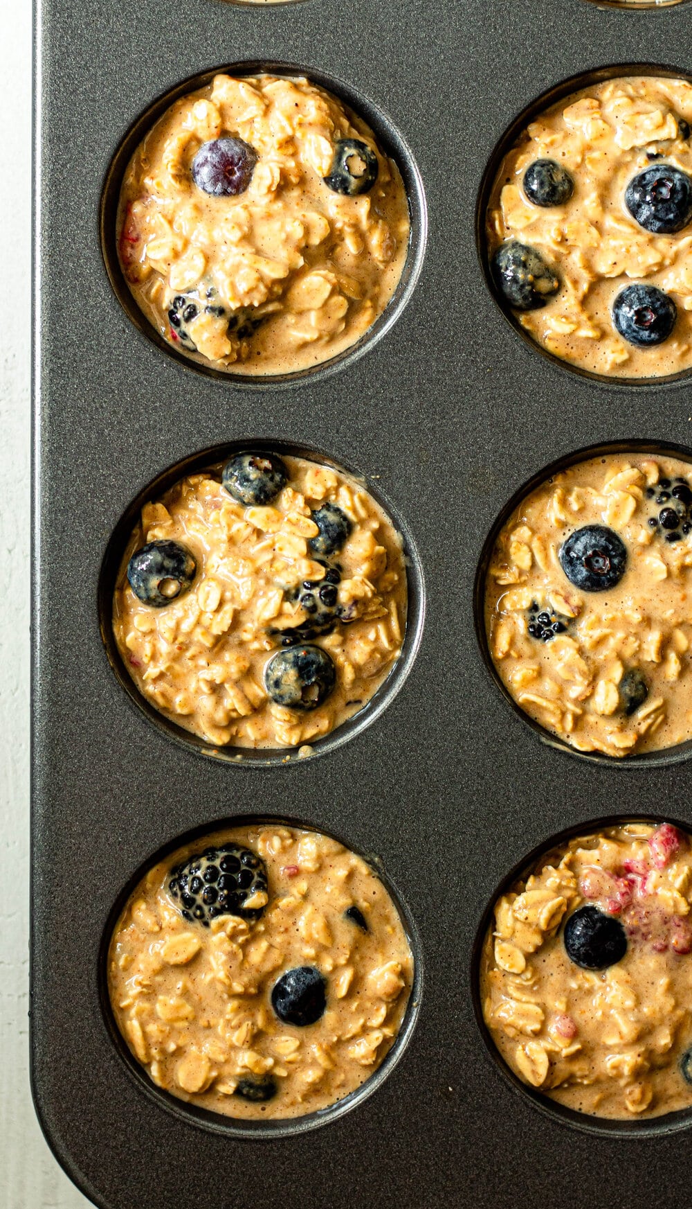 Triple Berry Baked Oatmeal Cup batter in a muffin pan