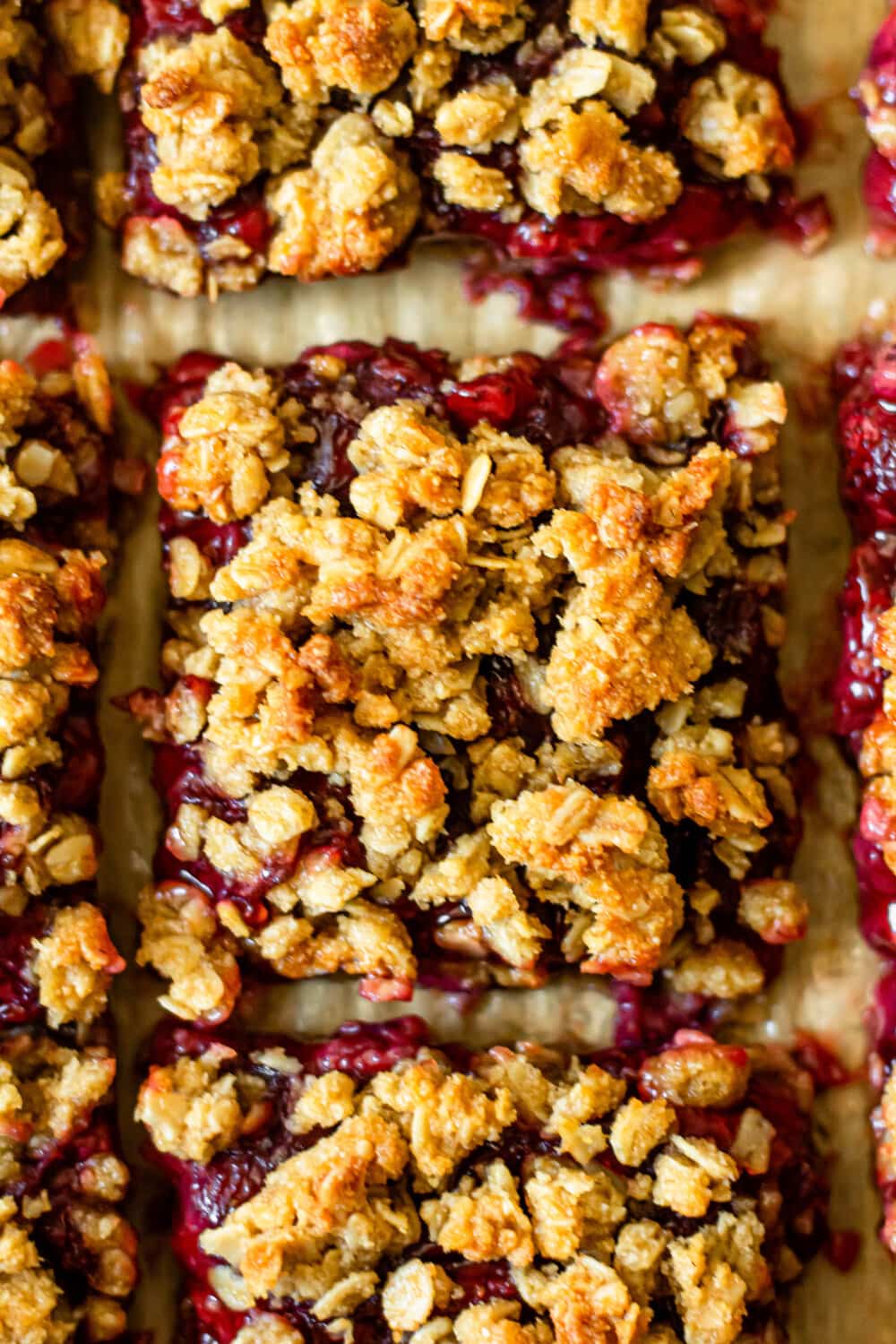 strawberry oatmeal crumb bars on brown parchment paper