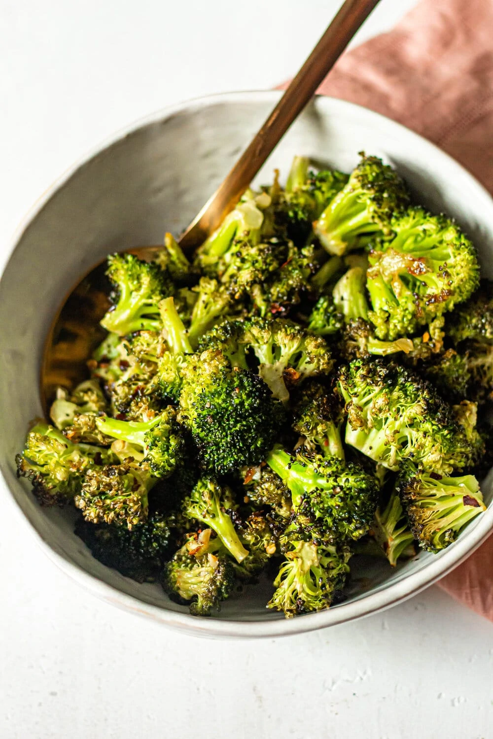 Roasted Garlic Lemon Broccoli in white bowl with gold spoon