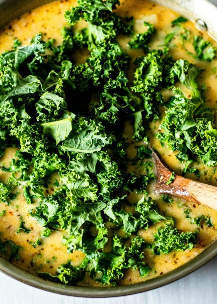 kale in pot with wooden spoon