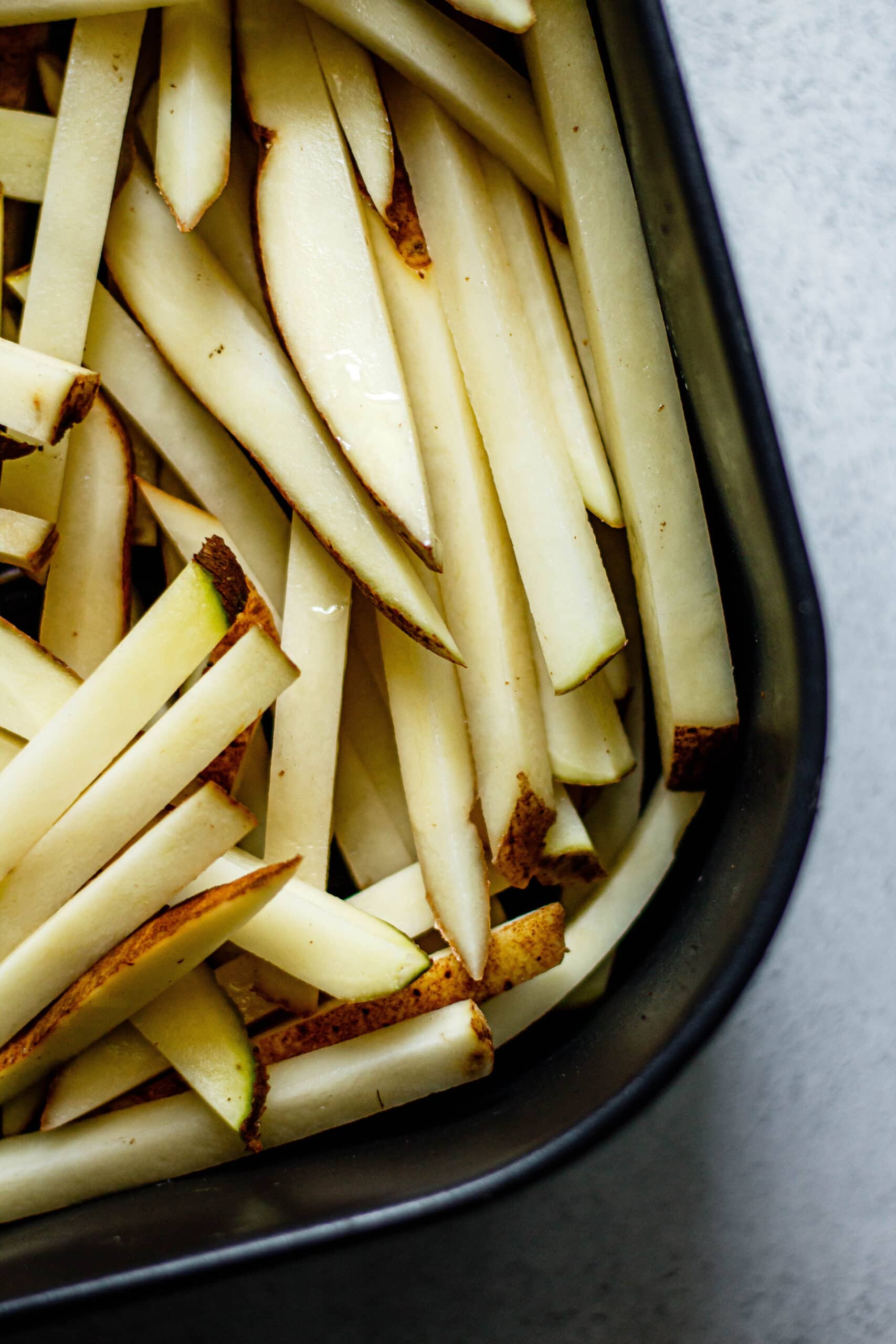raw French fries in black air fryer