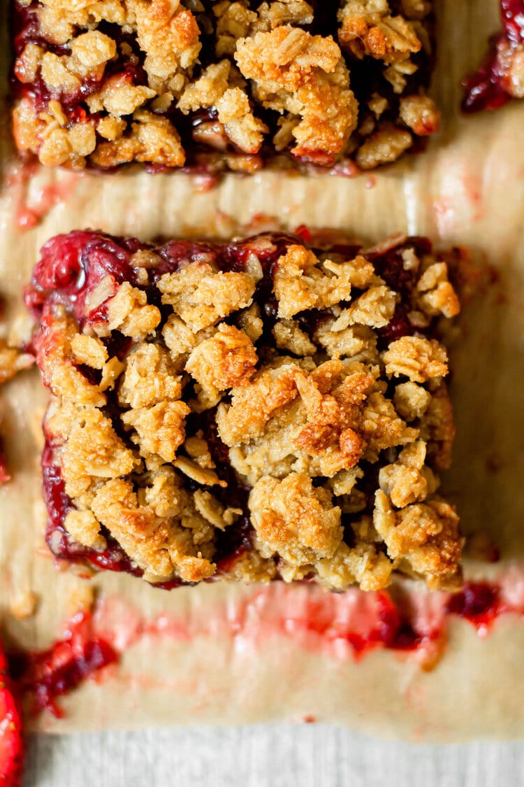 strawberry oatmeal crumb bars on brown parchment paper