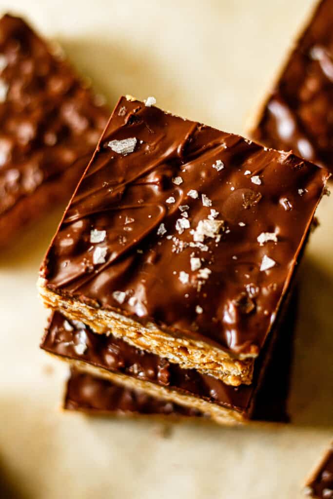 peanut butter chocolate rice crispy treats stacked on top of each other with sea salt sprinkled on top