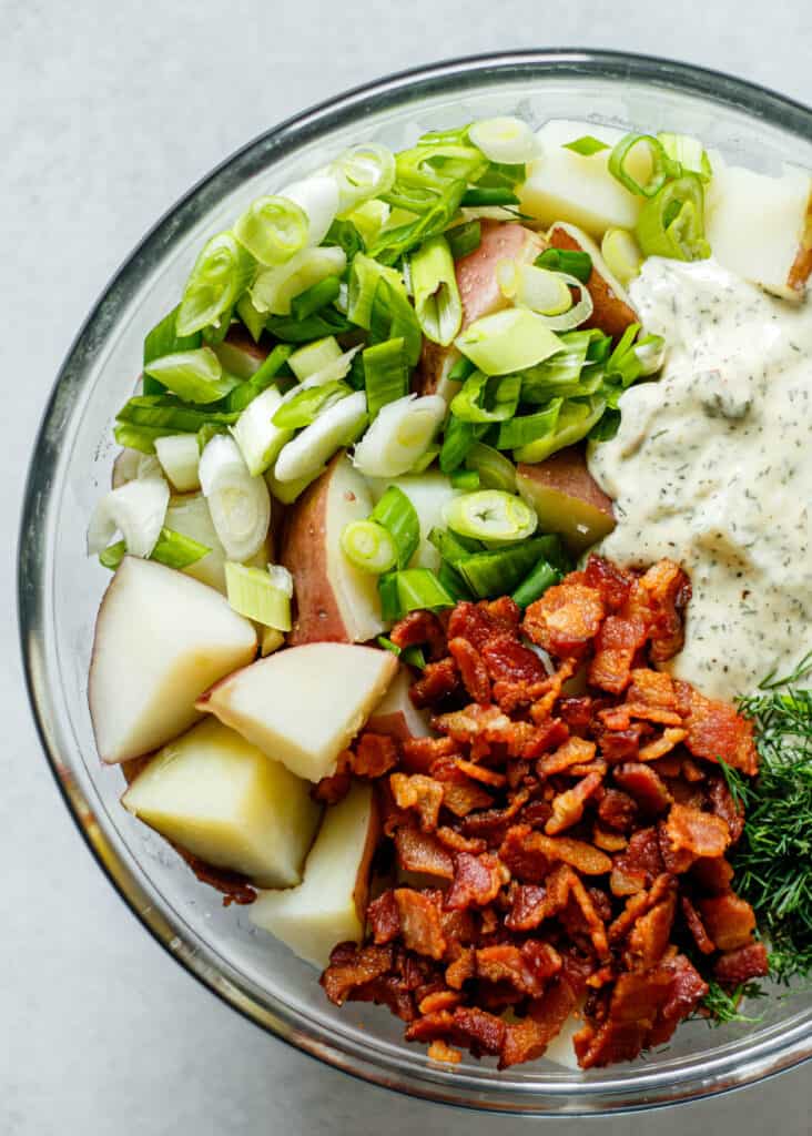 bacon, potatoes, green onion, ranch dressing in glass mixing bowl