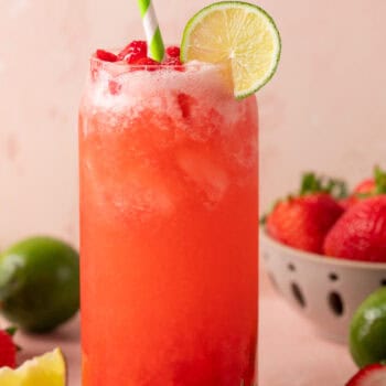 strawberry limeade in glass with lime slice and straw