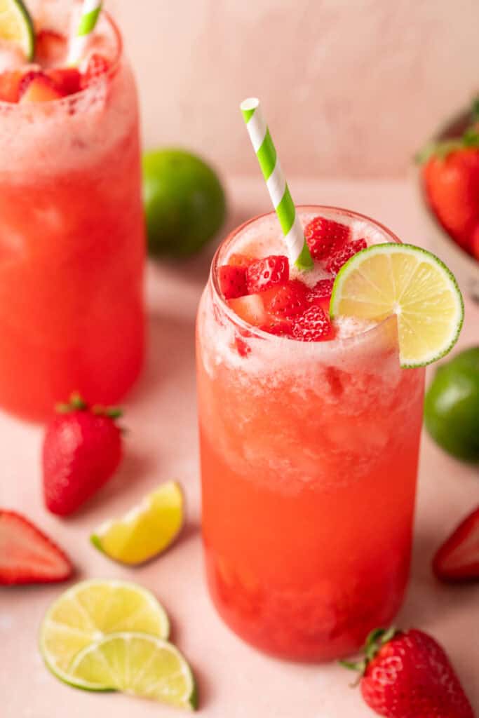 sparkling strawberry limeade in glass with straw