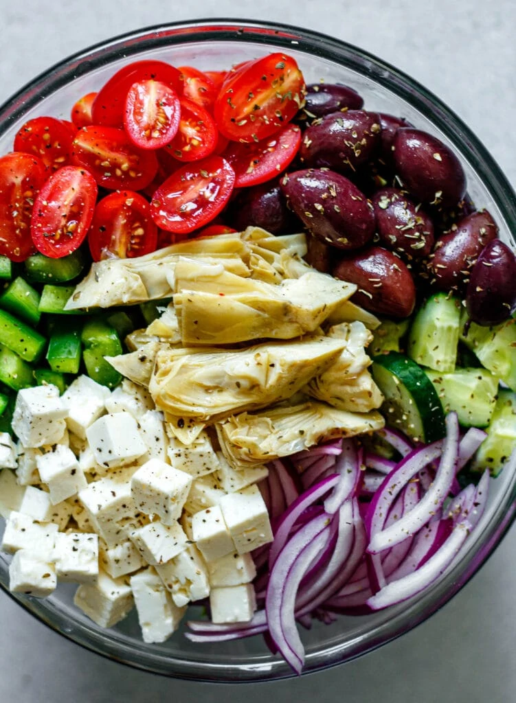 Greek salad ingredients in a large mixing bowl