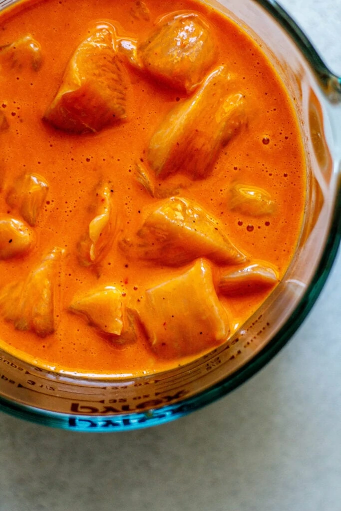 chicken in egg wash in mixing bowl