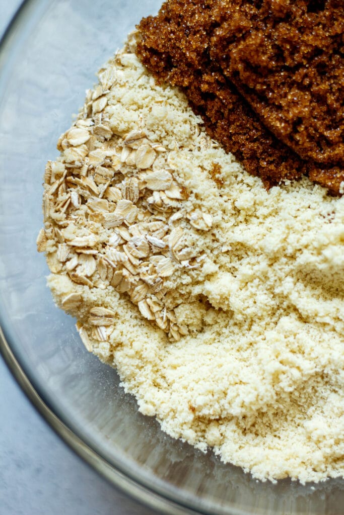 almond flour, brown sugar, and rolled oats in a glass mixing bowl
