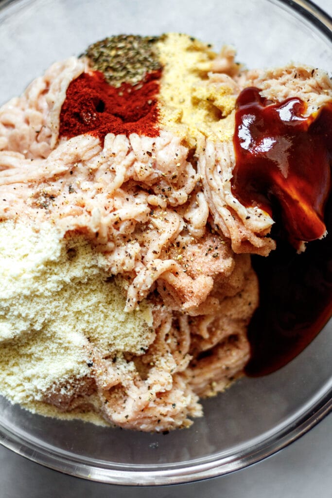 ground chicken, almond flour, bbq sauce, and spices in glass mixing bowl
