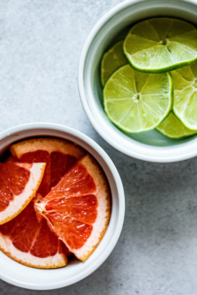 sliced grapefruit and lime in white bowls