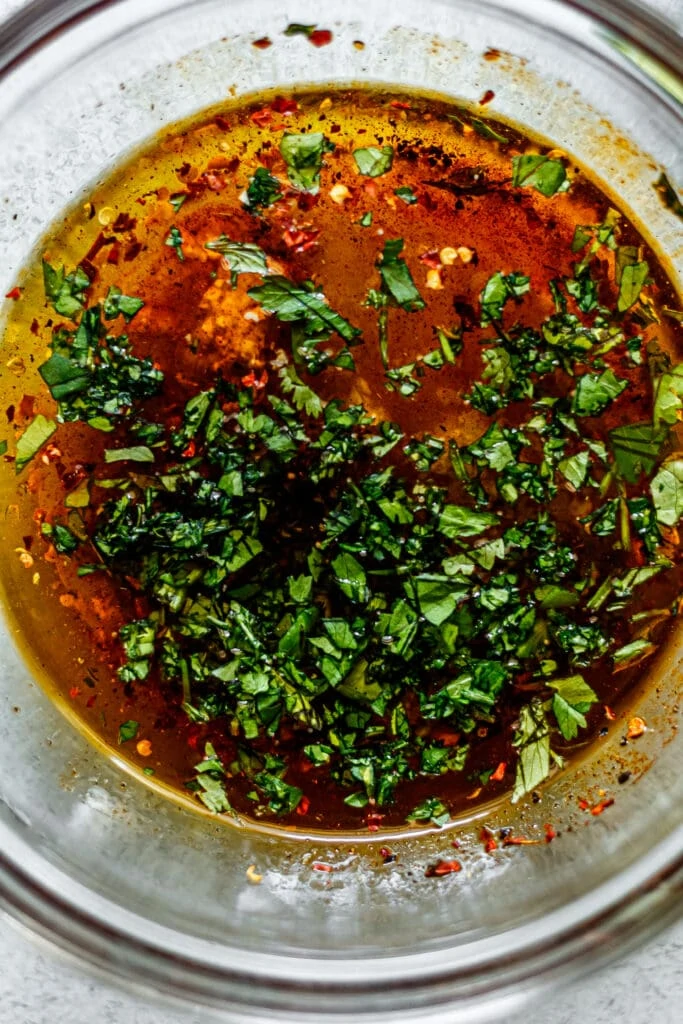 cilantro lime marinade with chopped cilantro on top in a glass bowl