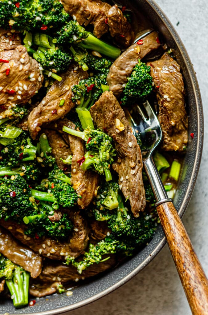 Healthy Beef and Broccoli in a grey dish with a fork on the side