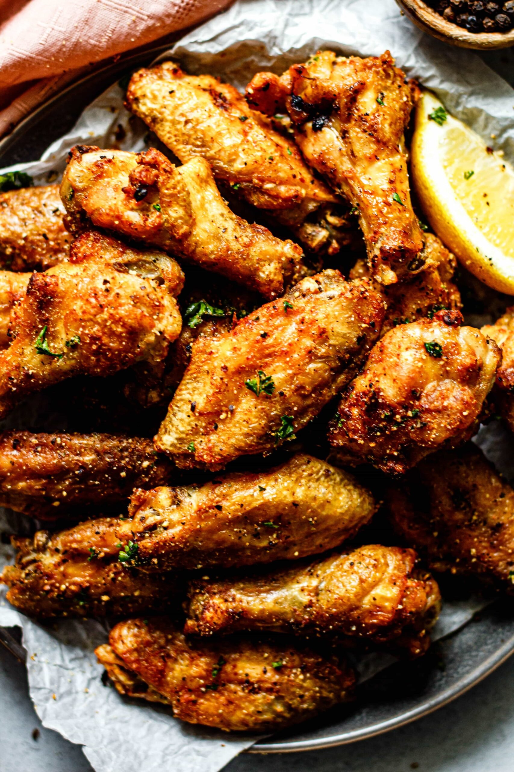 baked lemon pepper chicken wings on a plate with parchment paper