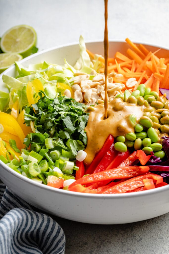 dressing being poured over salad