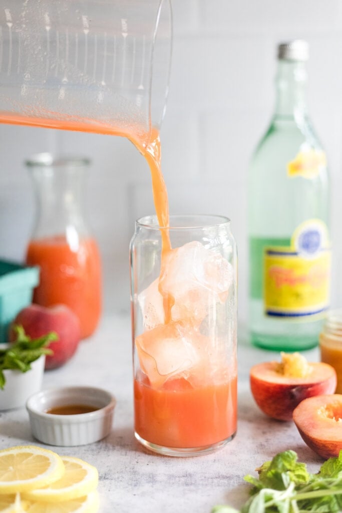 peach lemonade syrup being poured into glass
