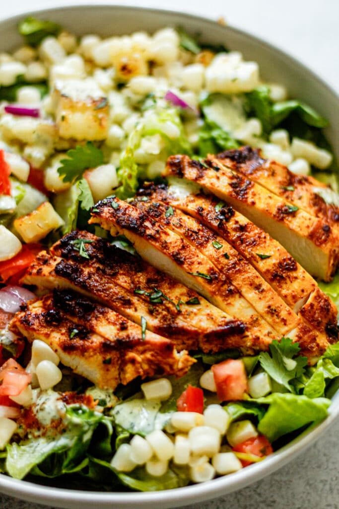 grilled chicken, salsa, corn, and romaine lettuce in a white bowl