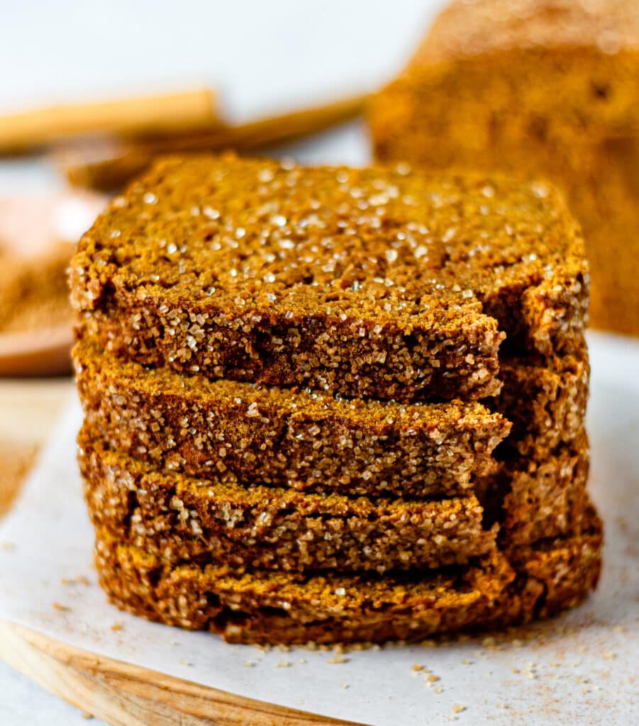 four pumpkin bread slices stacked on each other sprinkled with cinnamon sugar