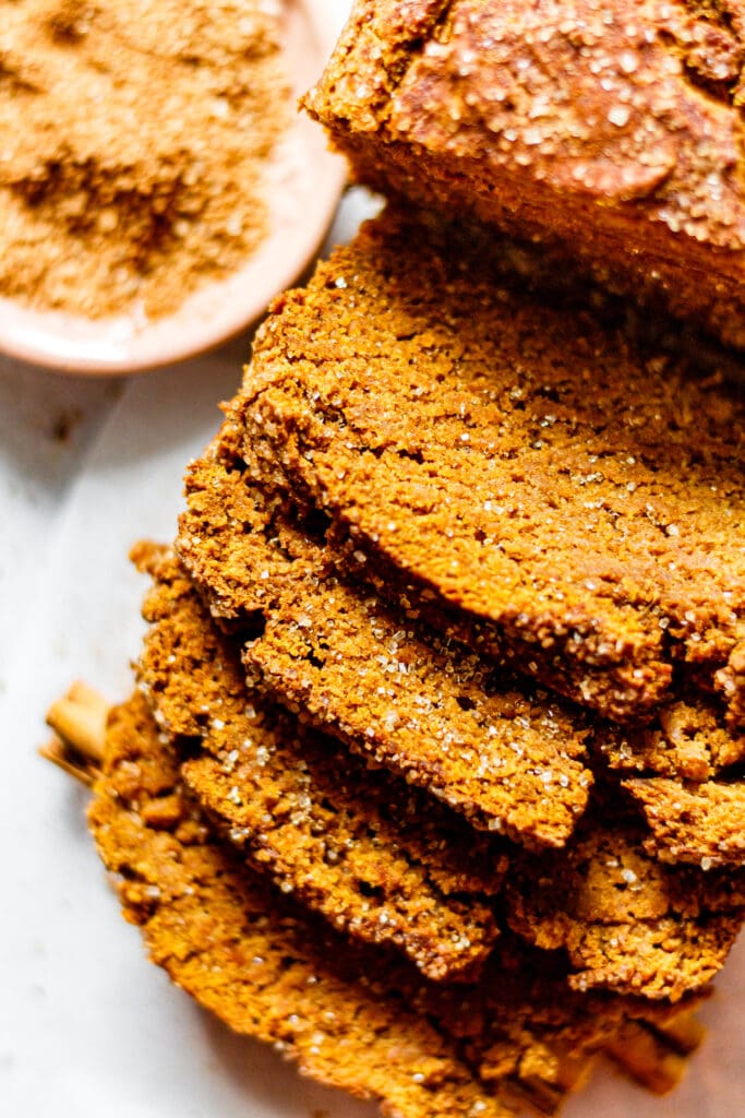 pumpkin bread cut into four slices with cinnamon sugar on the side