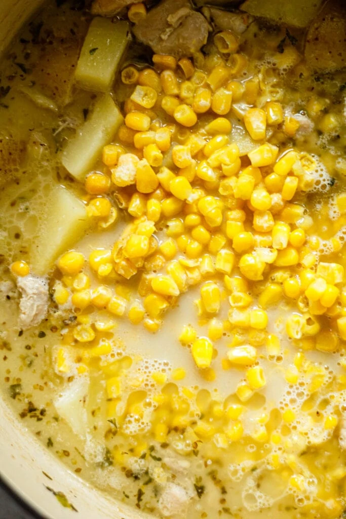 yellow corn, potatoes, chicken, broth, and spices in dutch oven