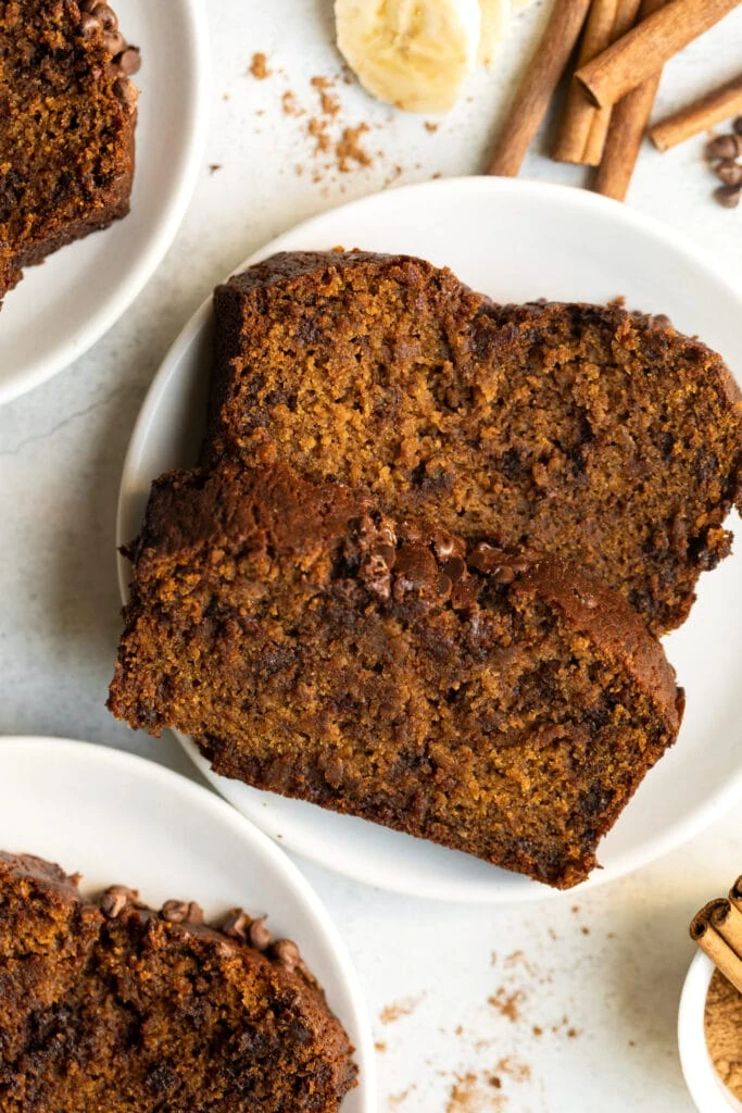 pumpkin banana bread slices on white plates