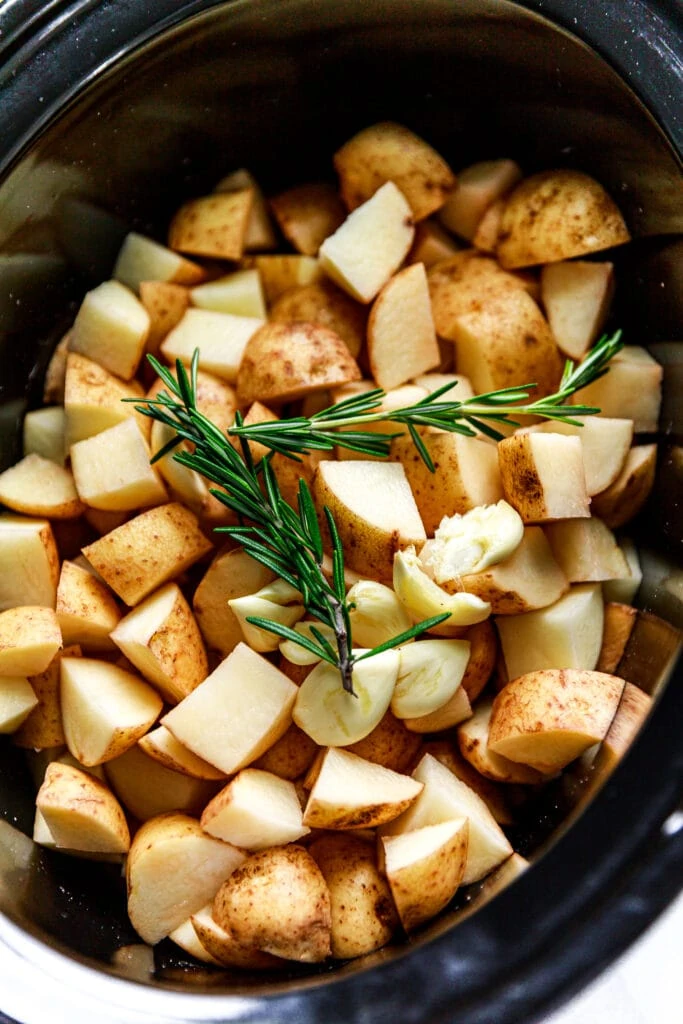 diced potatoes and rosemary in slow cooker