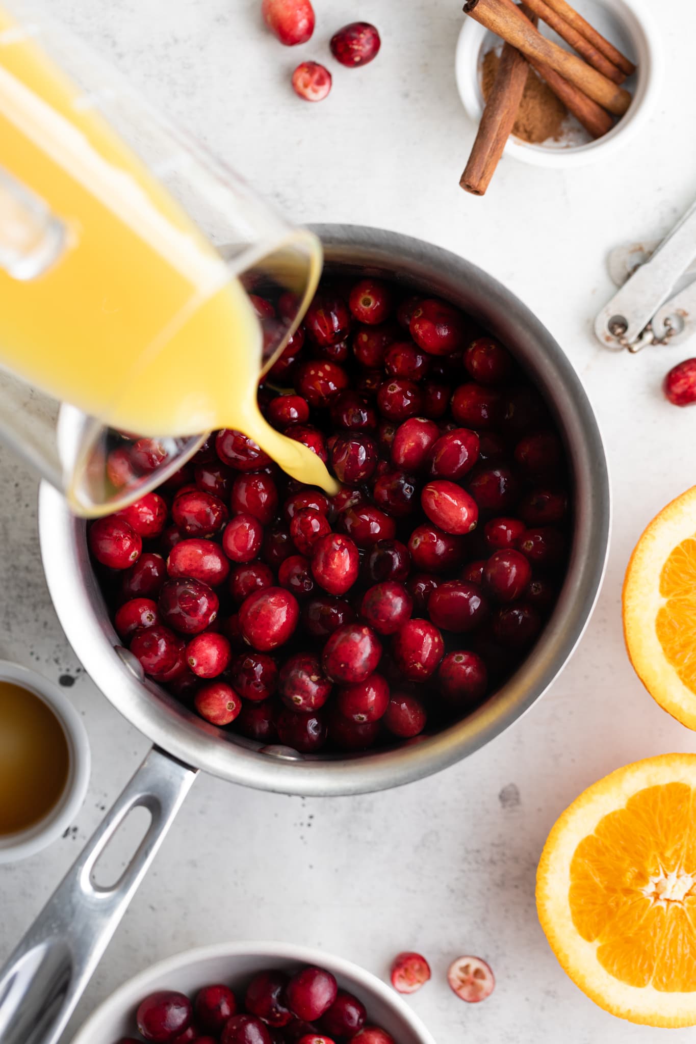 cranberries in pot with orange juice pouring in