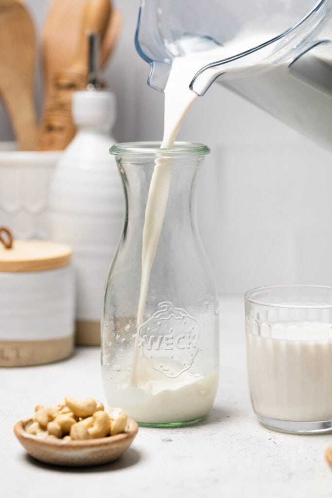 cashew milk being poured in to jar